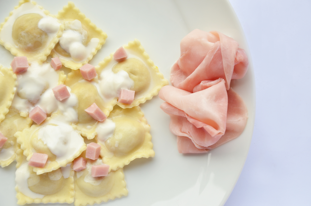 Ravioli di carne mit Sahne und gewürfeltem Schinken